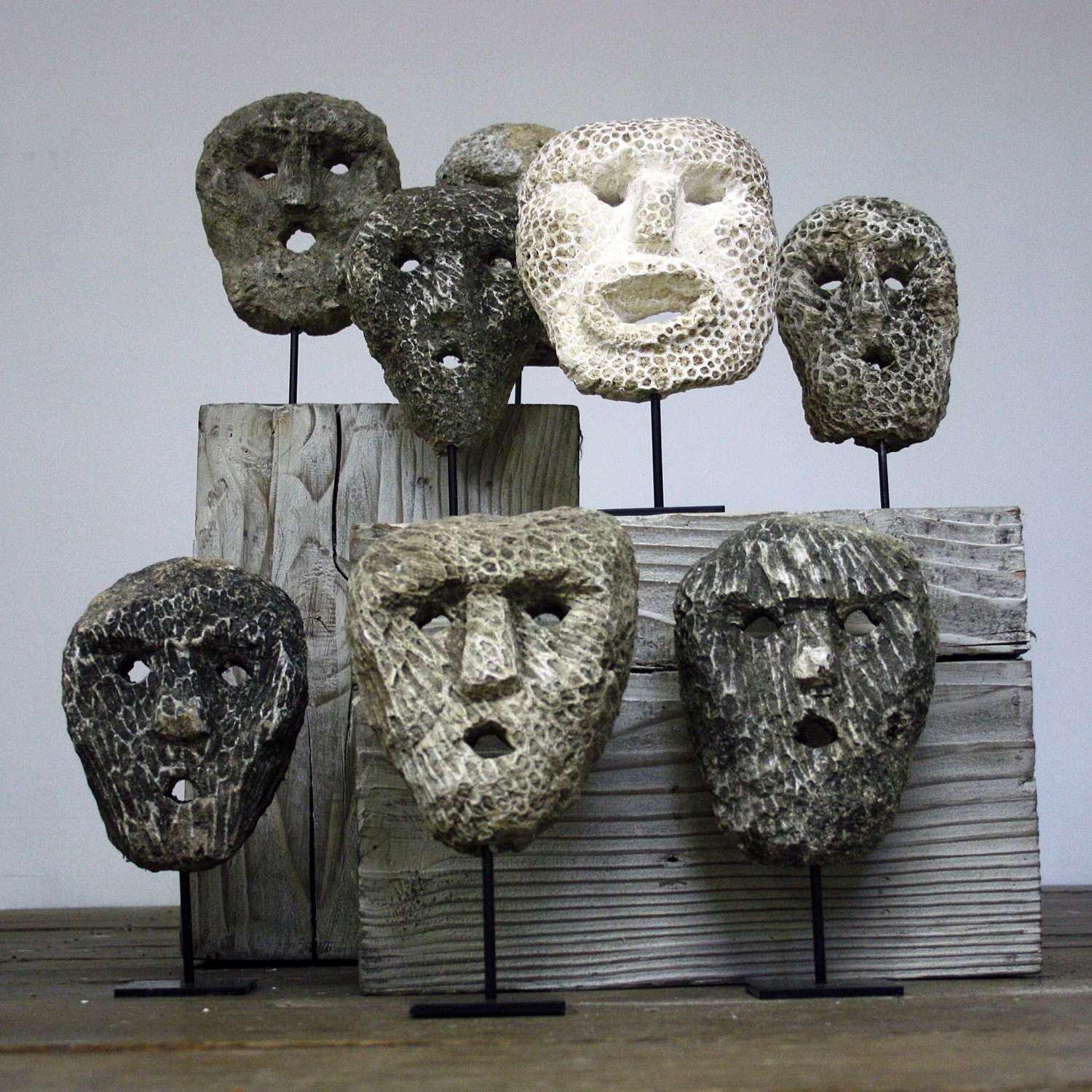 Collection of Fossillized carved coral animist Masks on stand